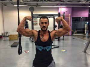 Antonio Ricky flexing his muscles at the gym